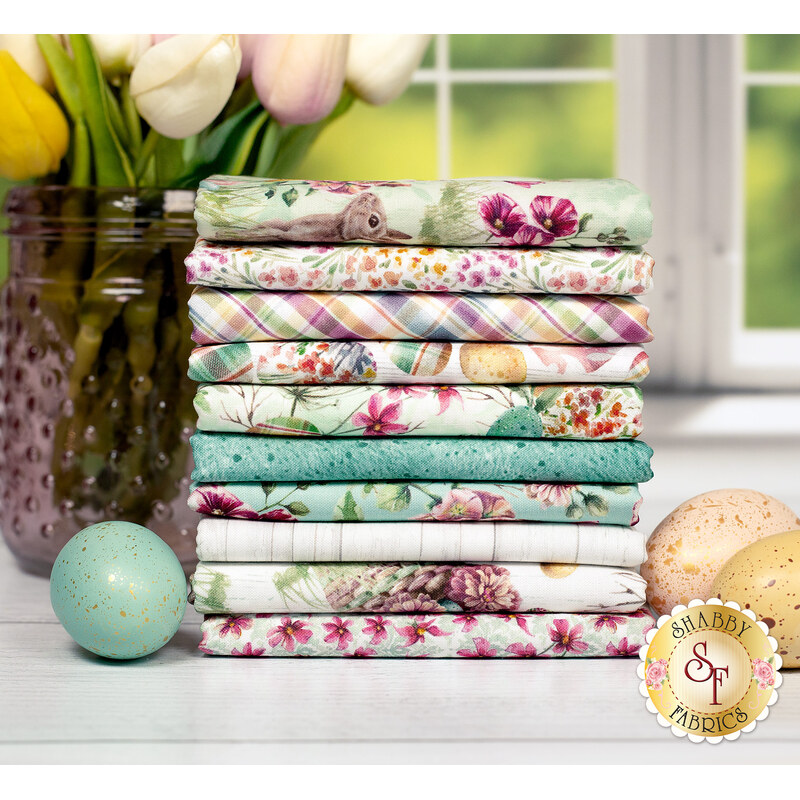 A stack of the Easter Wishes FQ set featuring bunnies, easter eggs and florals in cream, light green and turquoise, with flowers in a vase and eggs.