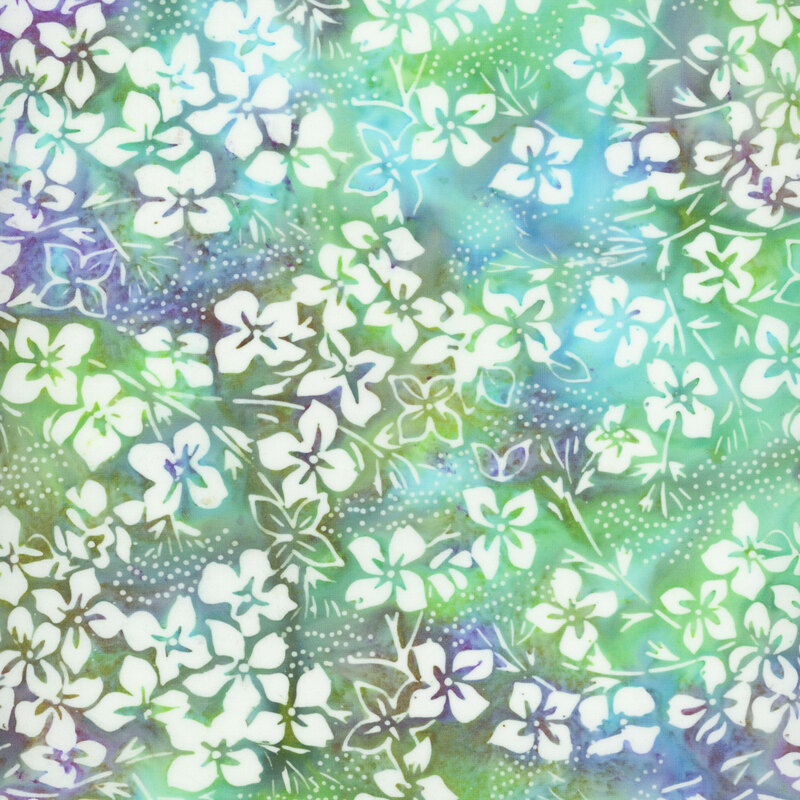 Mottled green and blue batik fabric with white florals all over