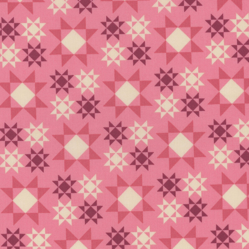 pink fabric with large dark pink and white Sawtooth Star quilt block patterns scattered across the fabric with smaller versions in purple and white are arranged in a square formation between the larger ones