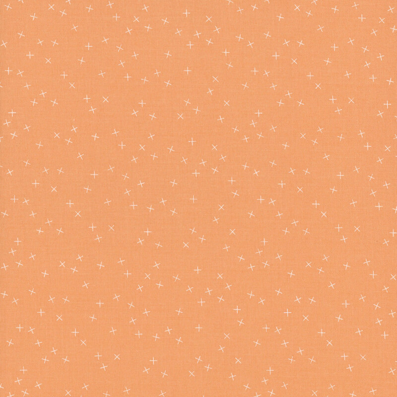 Peach fabric with small white X's scattered throughout