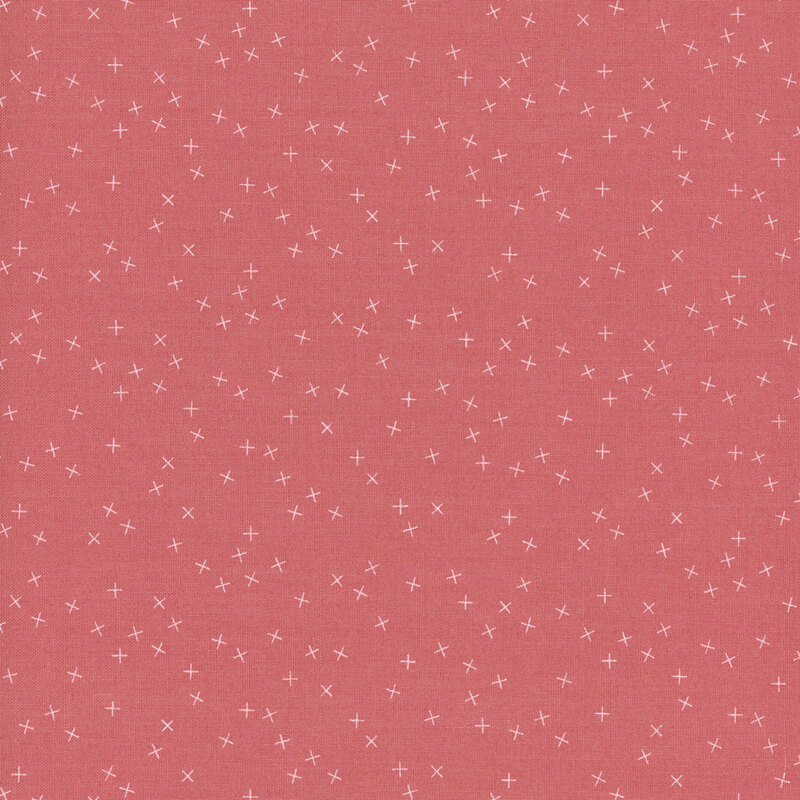 Coral pink fabric with small white X's scattered throughout