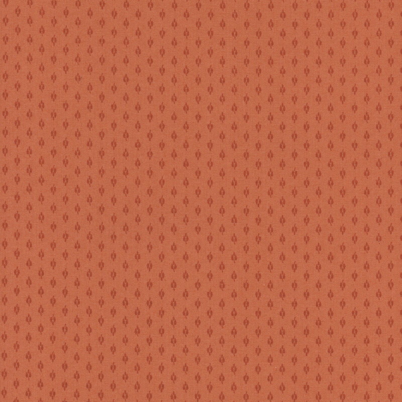 Peach fabric with small red repeating shapes all over