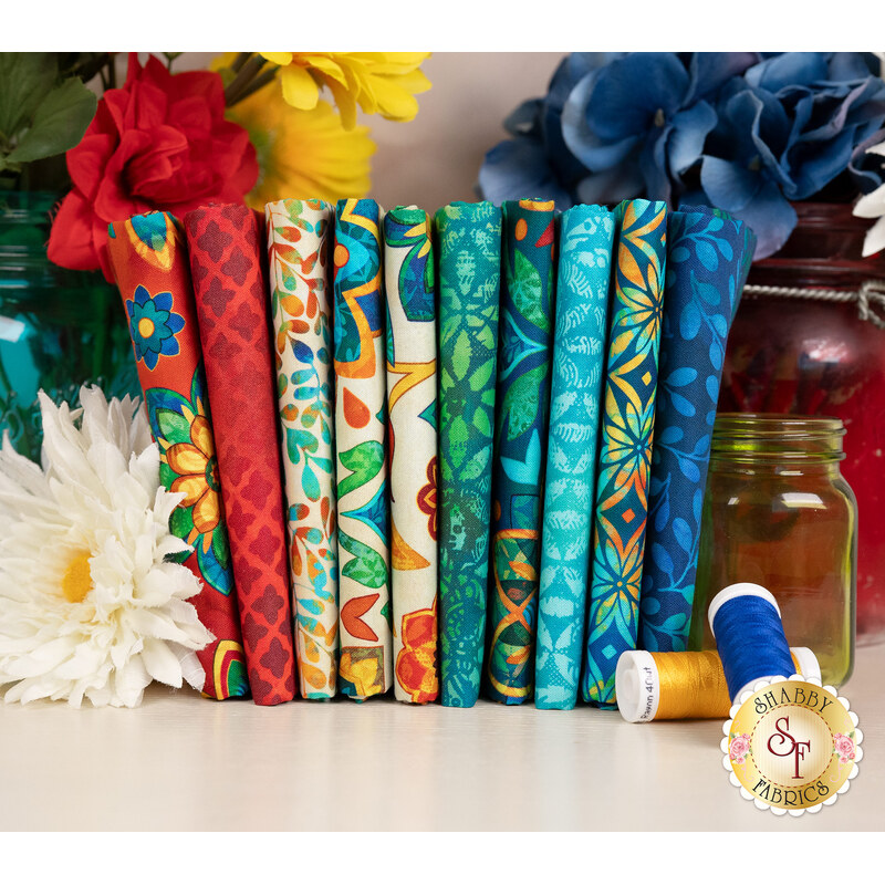 A stack of the fabrics in the Boho Blooms FQ set, with flowers and jars and thread.