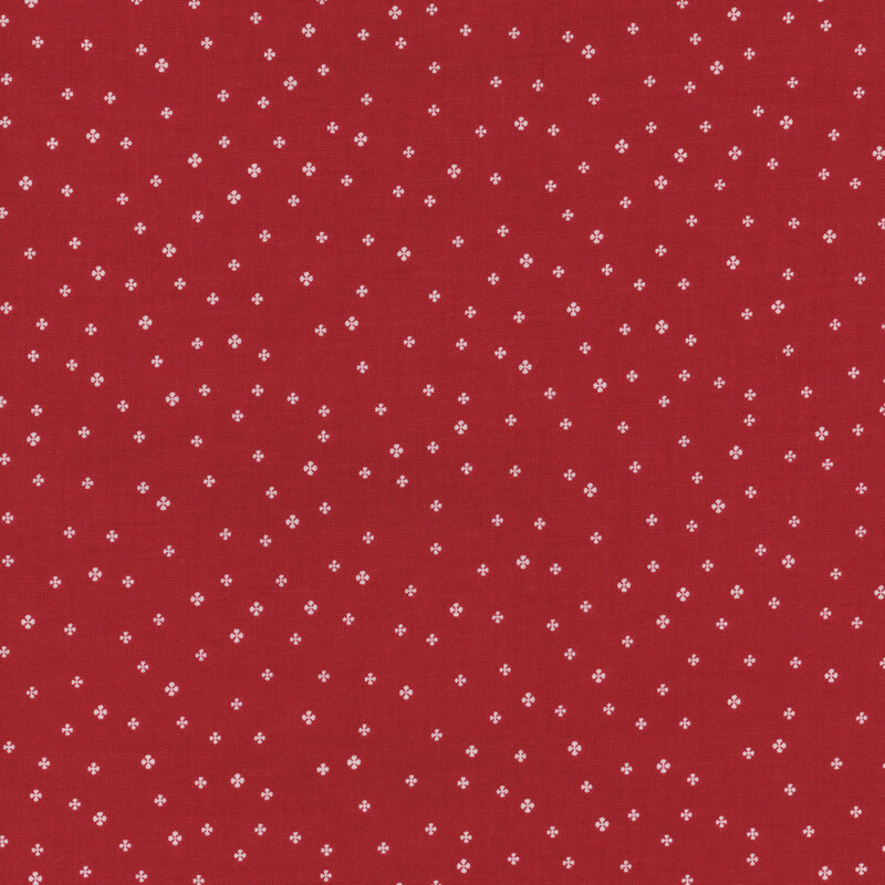 red fabric with tiny white simplified four-petaled flowers