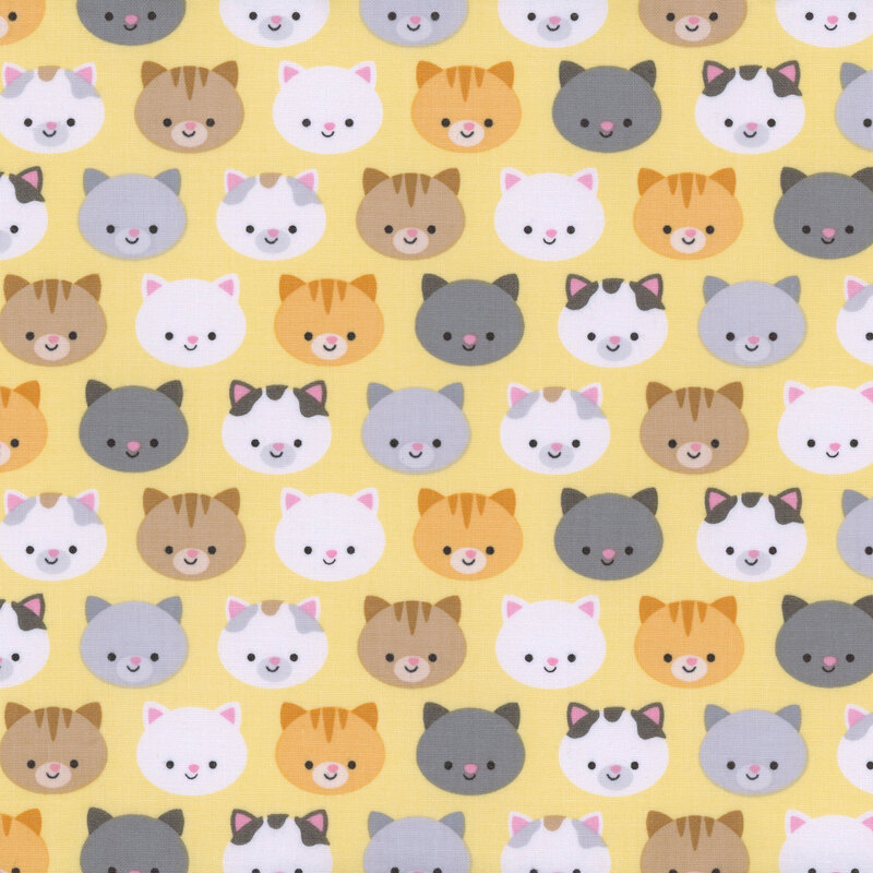 yellow fabric with colorful orange, black, gray, and white cat faces all over