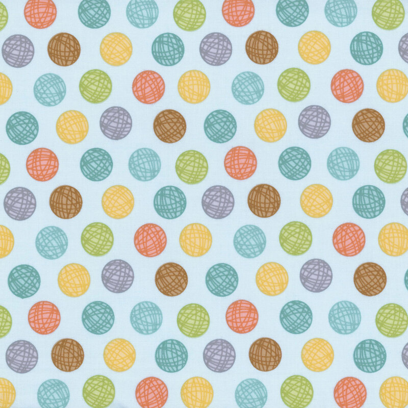 Blue sewing fabric with colorful balls of yarn polka dots all over