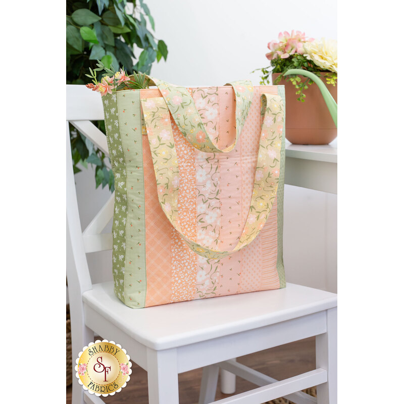 A shot of one side of the completed tote in Flower Girl, staged on a white chair.