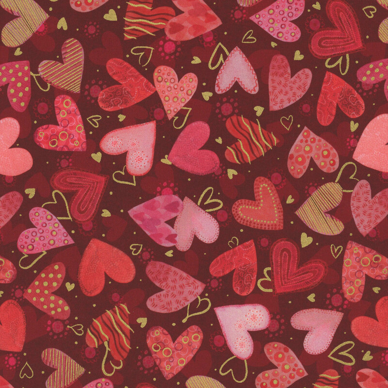 Dark red fabric with pink, red, and gold hearts with various designs all over