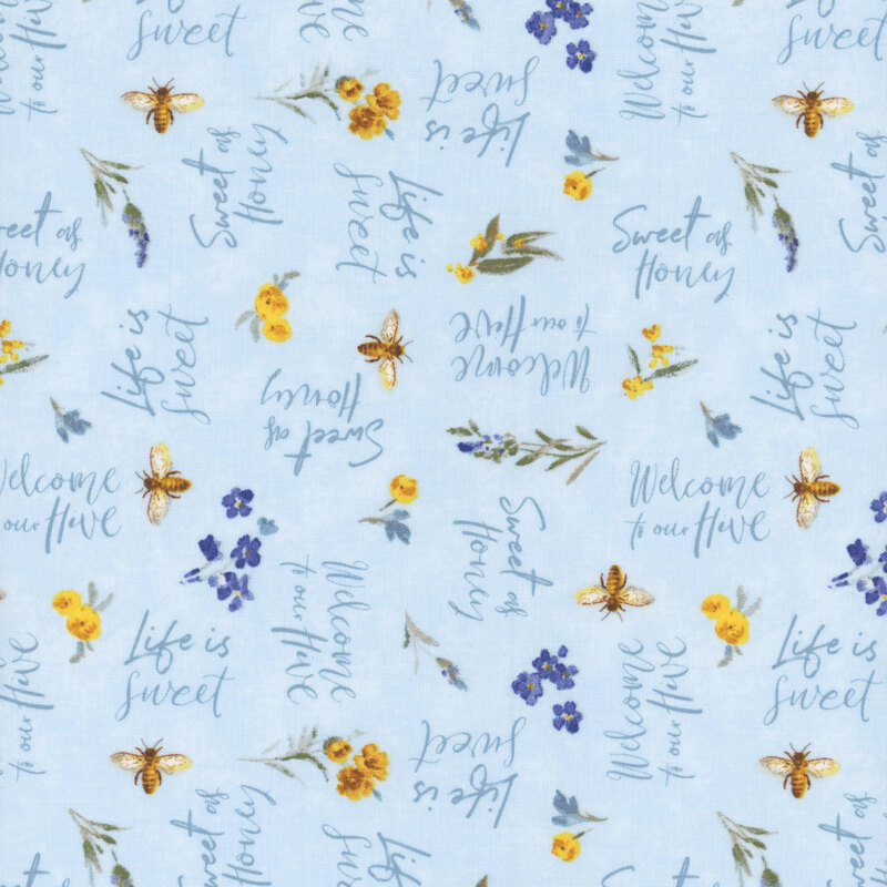 Light baby blue fabric with tossed florals, bees, and phrases in script font.