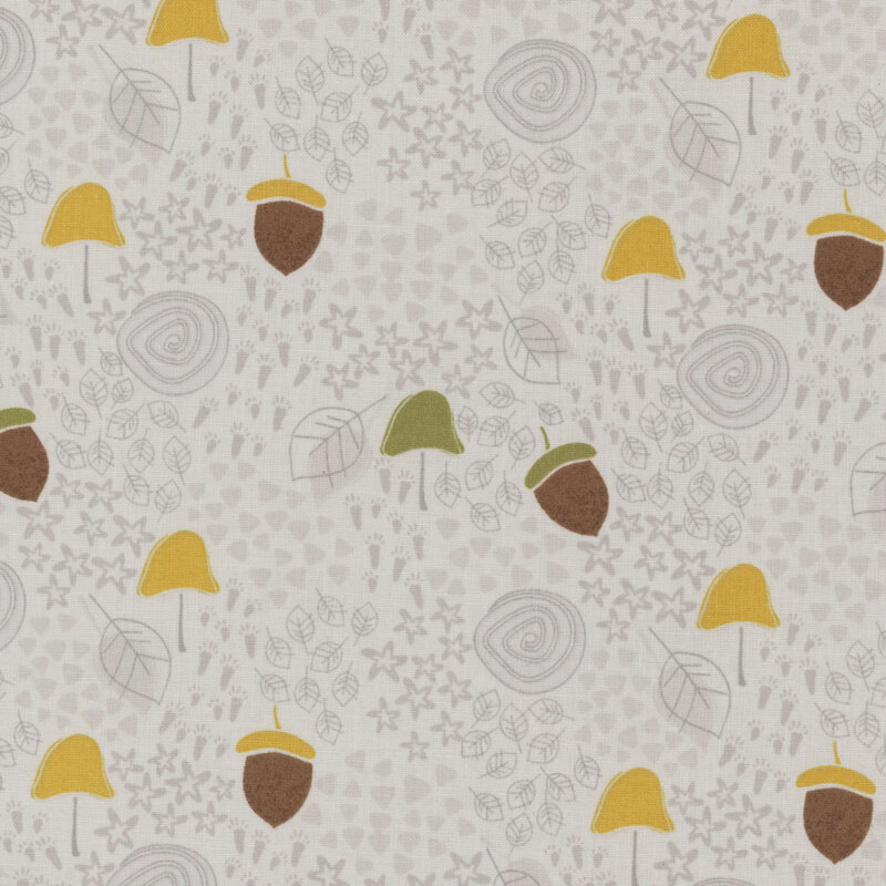 Gray fabric with dark gray stars, animal foot prints, and swirls in the background and tossed colorful leaves and acorns throughout