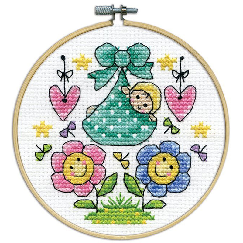 A closeup of the finished Bundle Of Joy cross stitch inside a wooden hoop isolated on a white background.