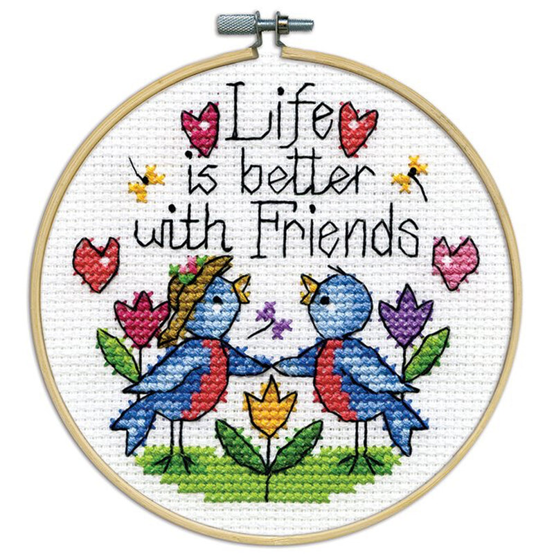 A closeup of the finished Friends cross stitch inside a wooden hoop isolated on a white background.