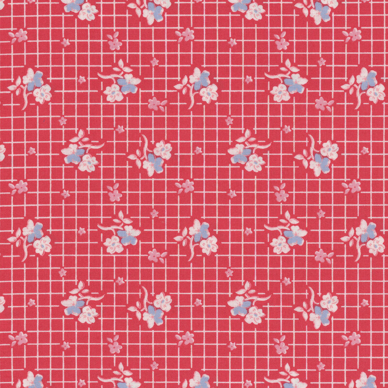 Red fabric with white, pink and blue flowers in rows on a white gridded background.