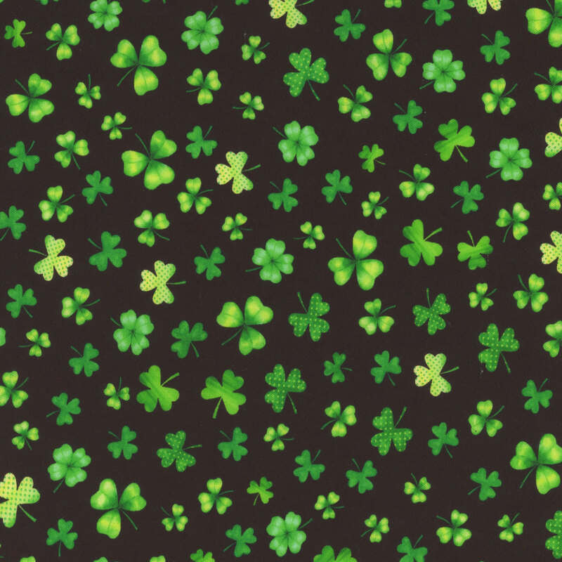 Black fabric scattered with various shamrocks and four leaf clovers