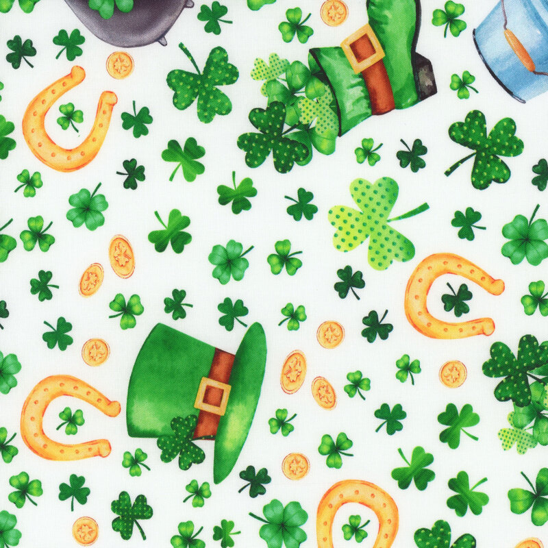 White fabric featuring shamrocks, a pot of gold, horseshoes, and other St Patricks Day motifs