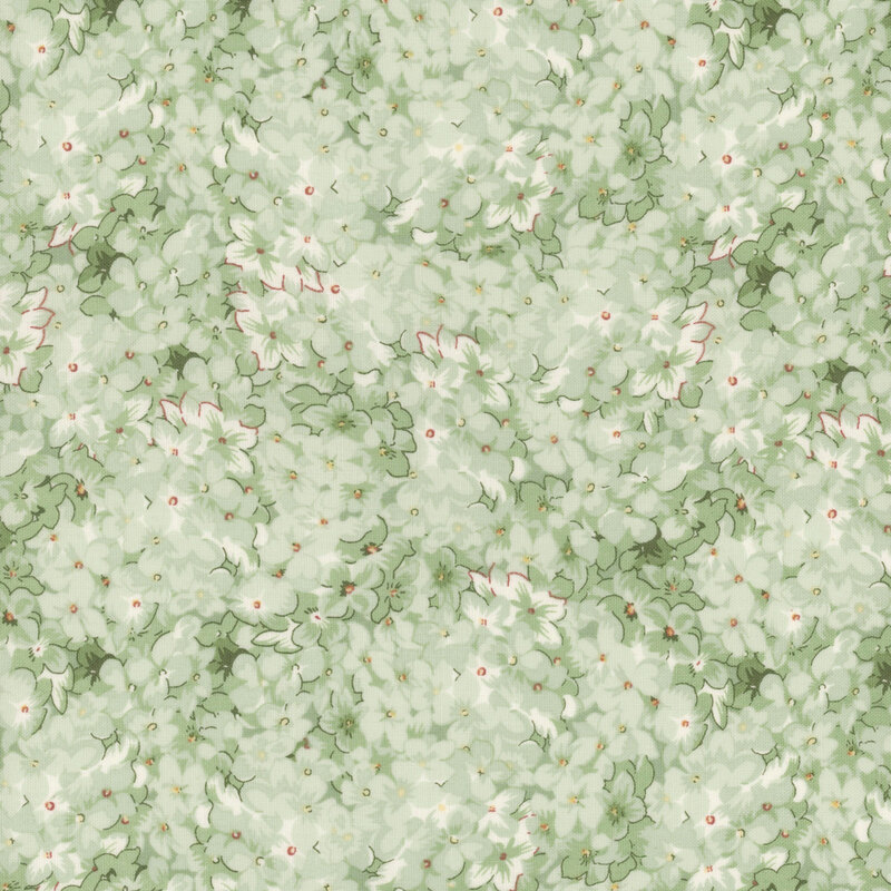 A swatch of green fabric with a packed pattern of flowers in light and dark shades and variegated versions.