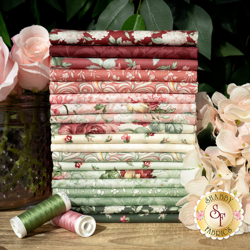 A stack of fabrics in shades of red, white, and green, available in the Regal Rose FQ Set, with flowers, a vase, and thread.