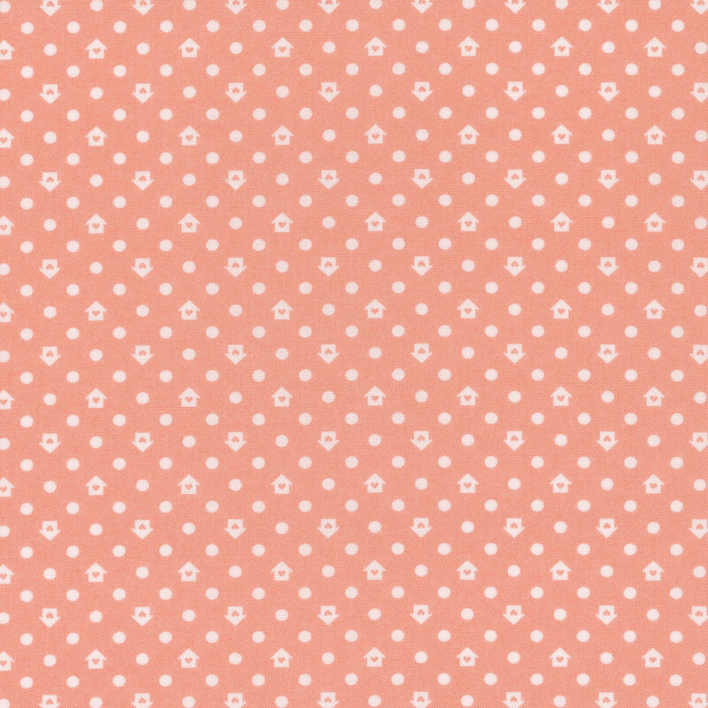 Peach colored fabric with a white house and dot pattern