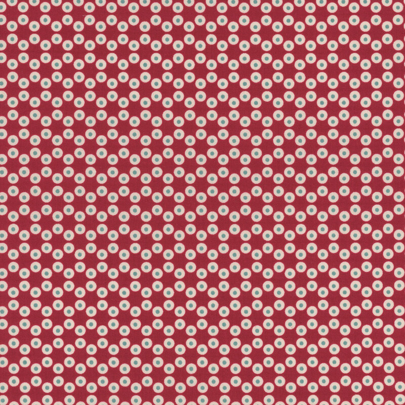 Barn red fabric with small circular dots making a connected hexagon pattern throughout