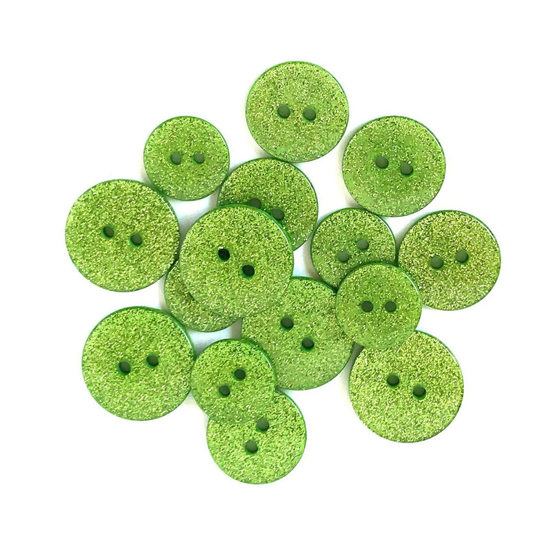 Pile of green glitter buttons against a white background