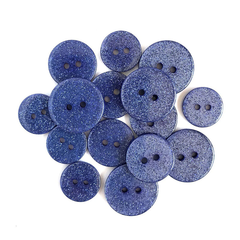 Pile of blue glitter buttons against a white background