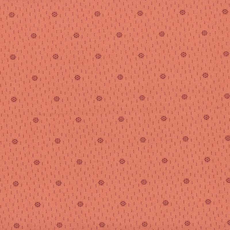 A coral fabric with a tonal starbursts of dotted clusters and dotted lines.