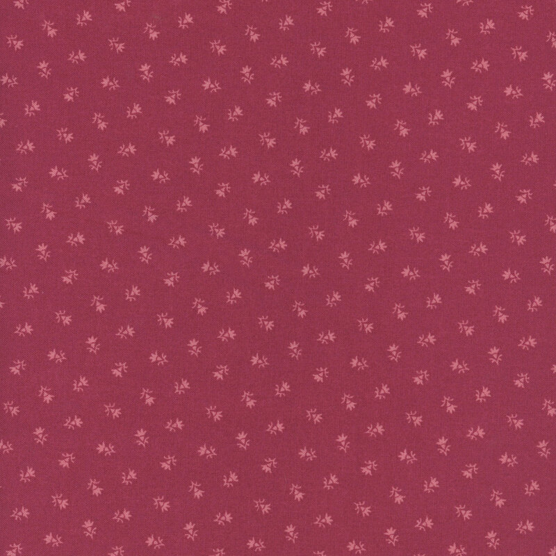 A raspberry red fabric pattern with small, delicate floral designs scattered throughout.