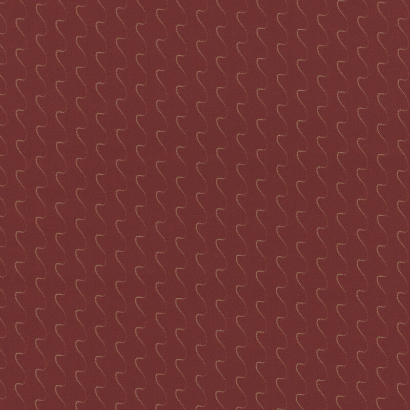 Red fabric with wavy gold lines forming a repeating pattern.