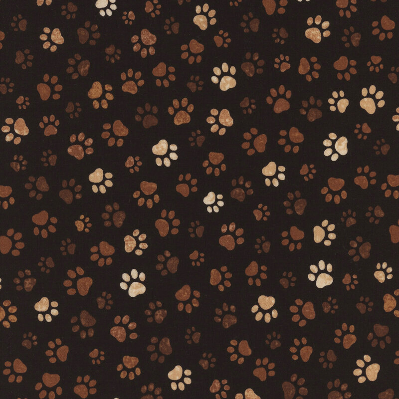 Black fabric featuring various-sized brown and cream paw prints