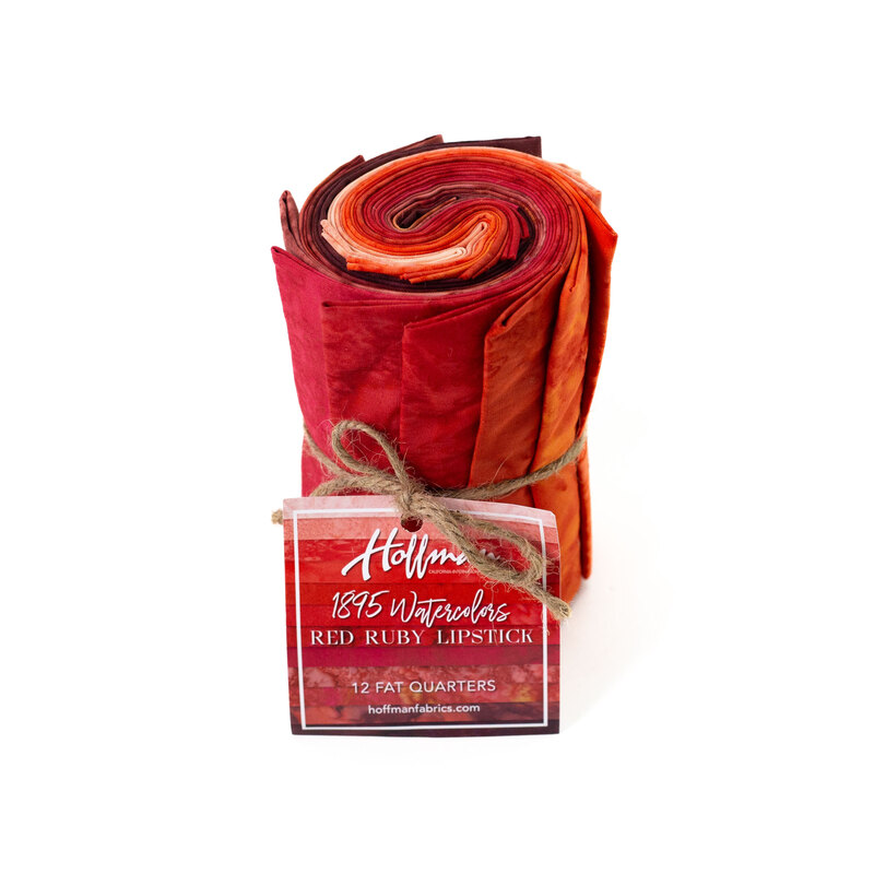 Rolled fabric bundle labeled Red Ruby Lipstick, featuring 12 fat quarters in red and orange tones.