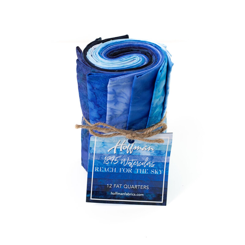 Rolled fabric bundle labeled Reach for the Sky, featuring 12 fat quarters in blue tones.