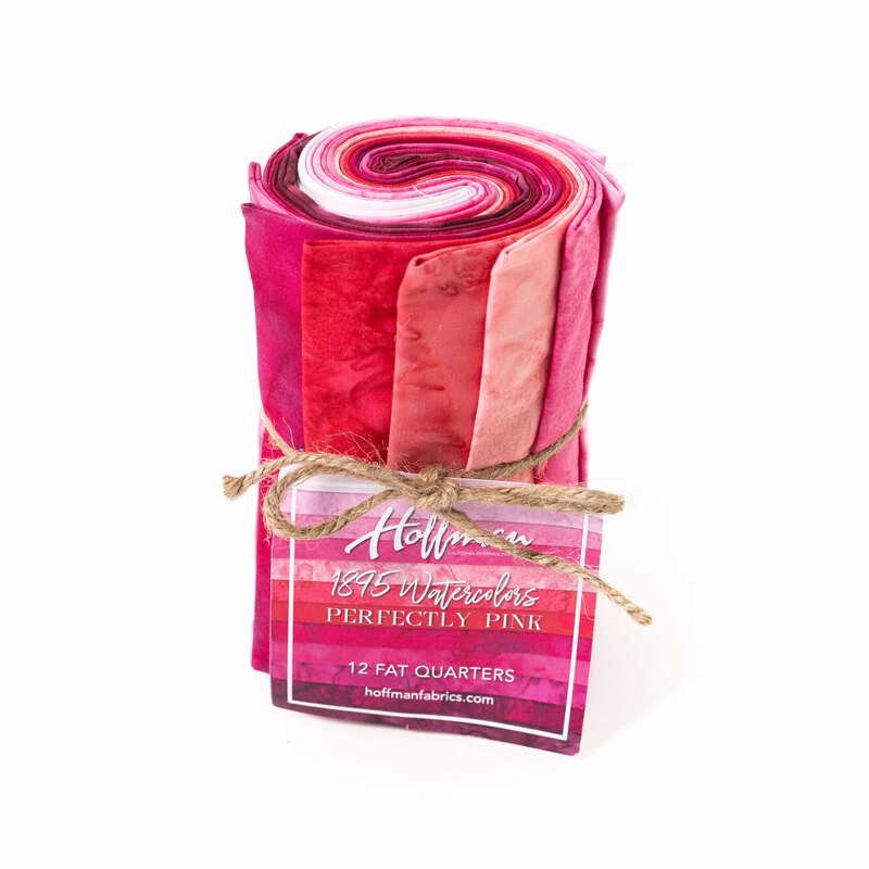 Rolled fabric bundle labeled Perfectly Pink, featuring 12 fat quarters in pink tones.