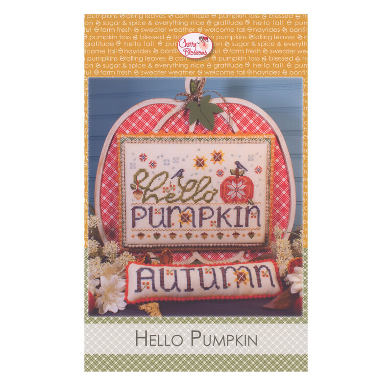 A pumpkin themed cross stitch project, framed by a decorative coordinating display.