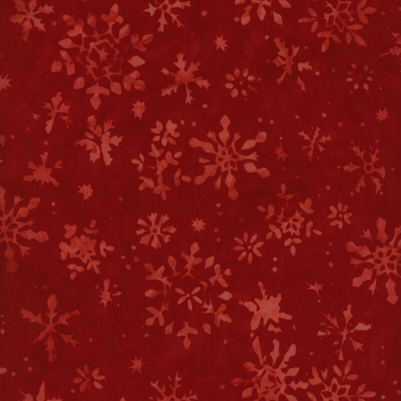 Red fabric with a pattern of varying snowflakes in shades of darker red and burgundy.