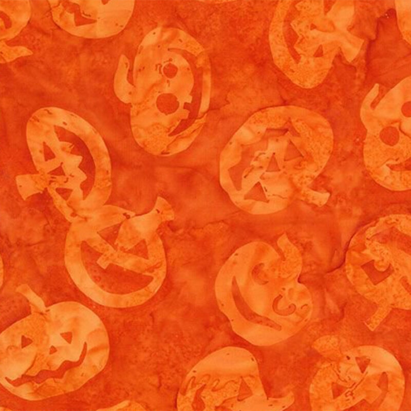 Bright orange mottled batik fabric with tonal orange jack-o-lanterns