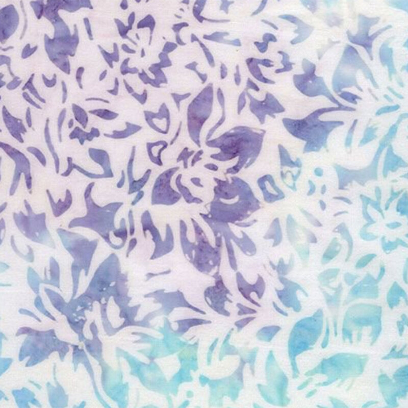 A floral batik featuring intricate purple and aqua designs layered over an off white background.