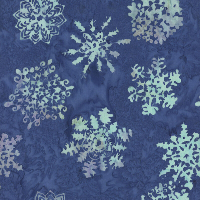 A textured blue batik scattered with various intricate white snowflake designs.