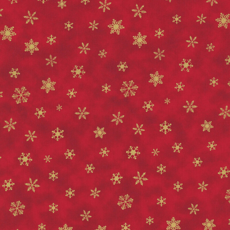 Red fabric patterned with various gold snowflakes on a festive background.