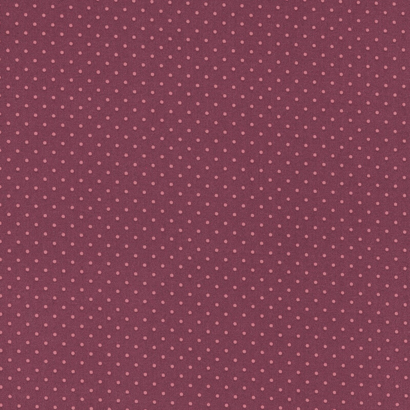 Burgundy fabric with a repeating pattern of small pink dots throughout.
