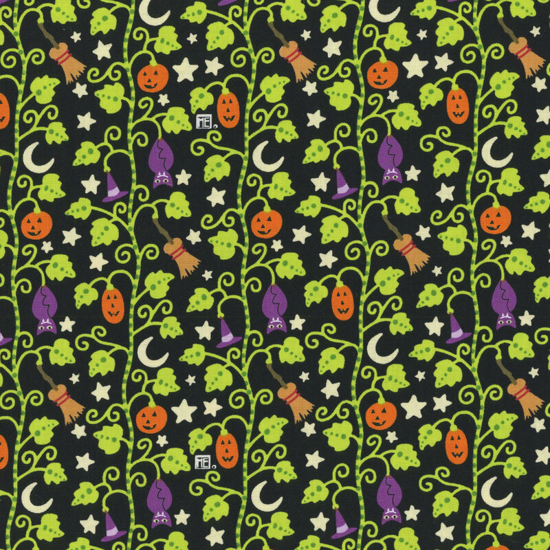 Black fabric with a bright pumpkin patch design with vines stretching across the fabric, and bats, stars, brooms, pumpkins, and stars are nestled within the leaves.