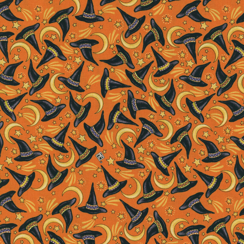 Muted orange fabric with tossed witch hats amongst crescent moons and stars.