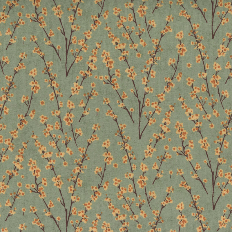 Sage green fabric covered with delicate branches and yellow flowers, creating a floral pattern.