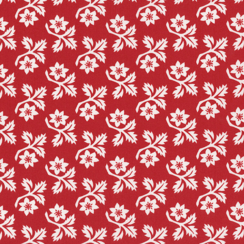 Red fabric with rows of white angular leaves and flowers with red centers.