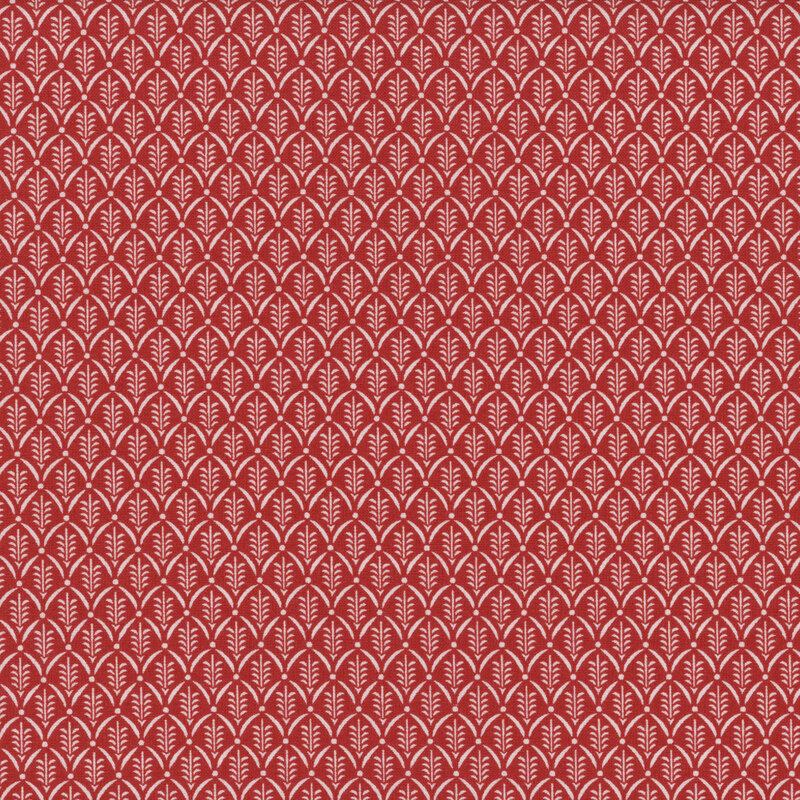 Red fabric with a white pattern of scallops framing little sprigs.