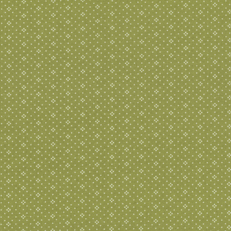 A textured green fabric background with a scattered white dot pattern.