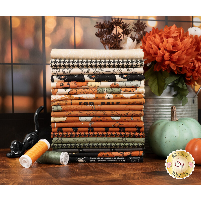 A stack of black, green, orange, and cream fabrics in the Home Sweet Haunt collection.