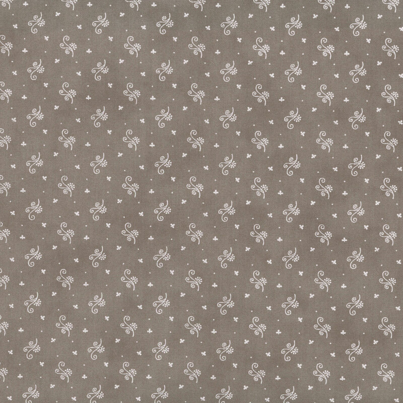 A mottled fabric pattern featuring small white floral designs on a muted brown background.