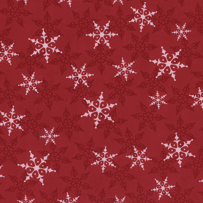 Red fabric with white and tonal snowflakes tossed across the design.