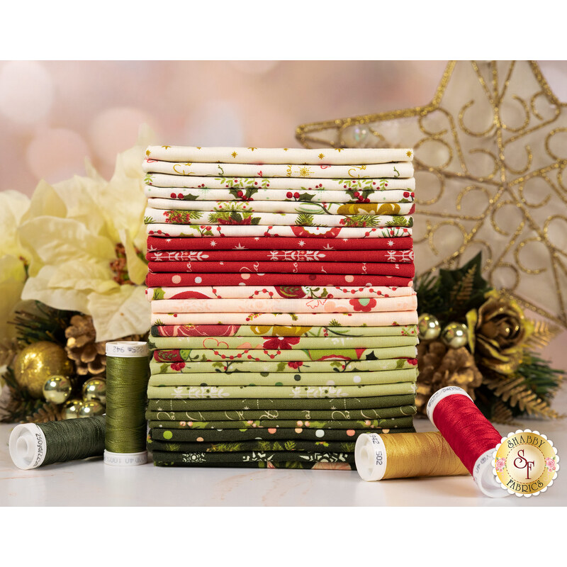 A stack of the fabrics in the Glisten FQ set, with golden flowers and a star and thread.