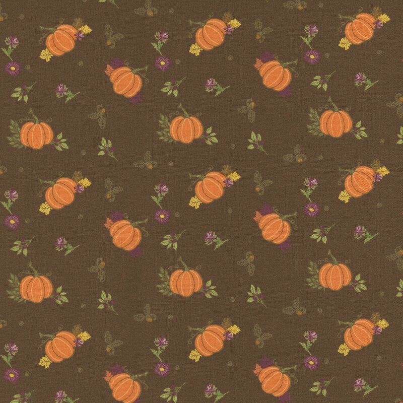 Fabric featuring orange pumpkins and small flowers on a dark brown background.